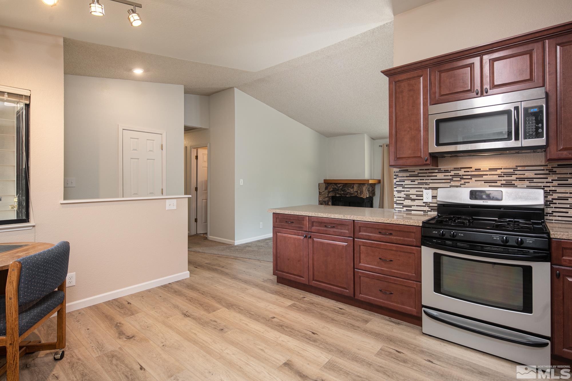 5335 Seville Court Reno, NV 89523 - Photo 7 of 31 a kitchen with stainless steel appliances granite countertop a stove microwave and refrigerator