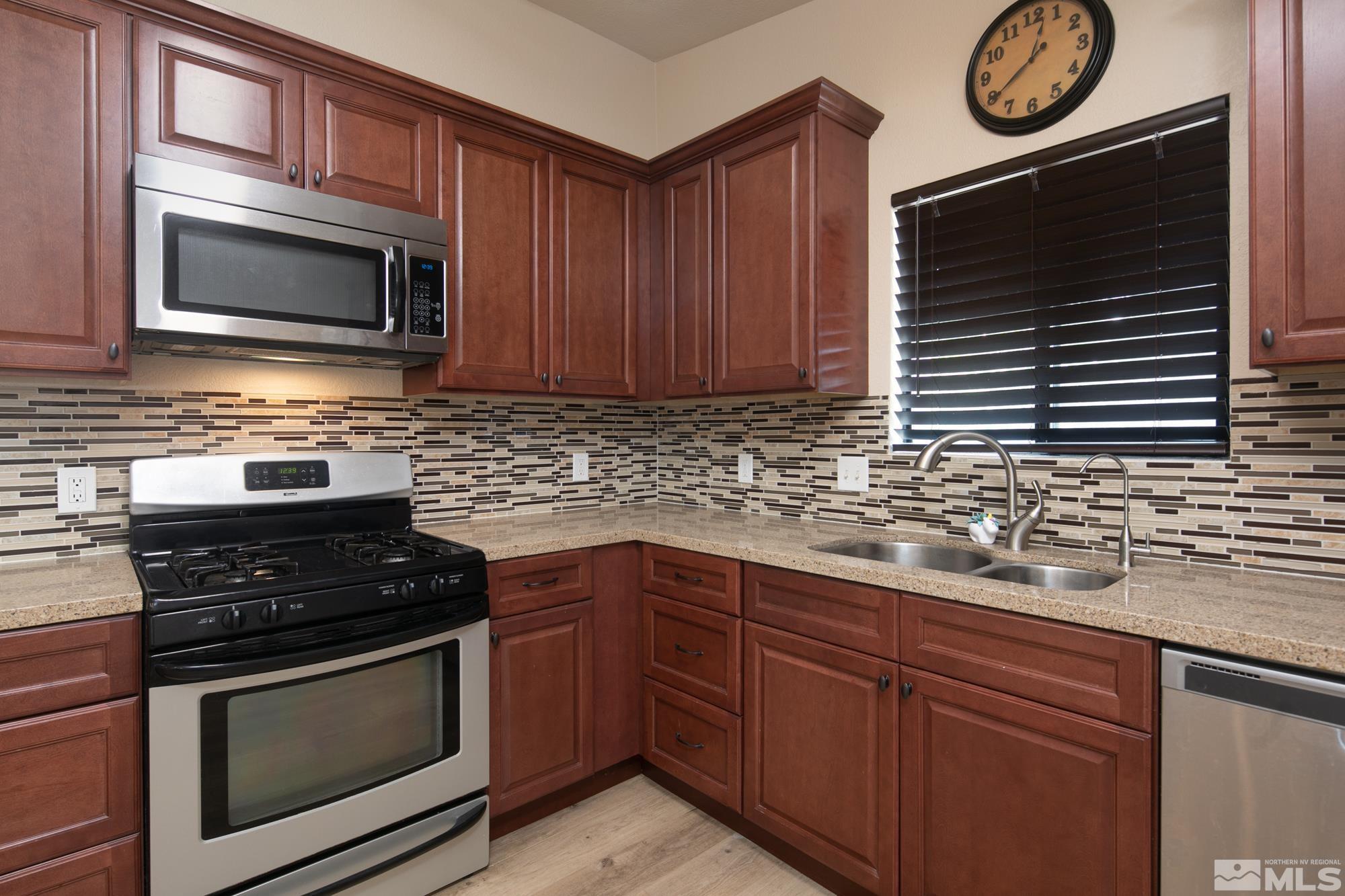 5335 Seville Court Reno, NV 89523 - Photo 8 of 31 a kitchen with granite countertop stainless steel appliances a stove a microwave a sink and cabinets