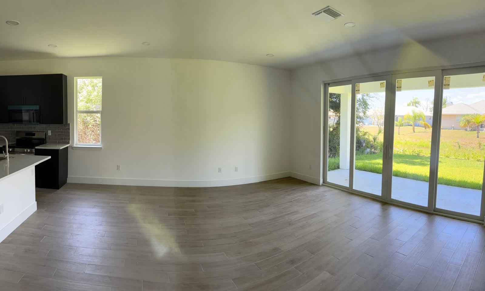 500 Sunset Road North Rotonda West, FL 33947 - Photo 7 of 25 an empty room with wooden floor and windows