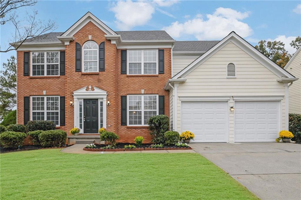 11420 Crossington Road Alpharetta, GA 30005 - Photo 1 of 39 a front view of a house with a yard and garage