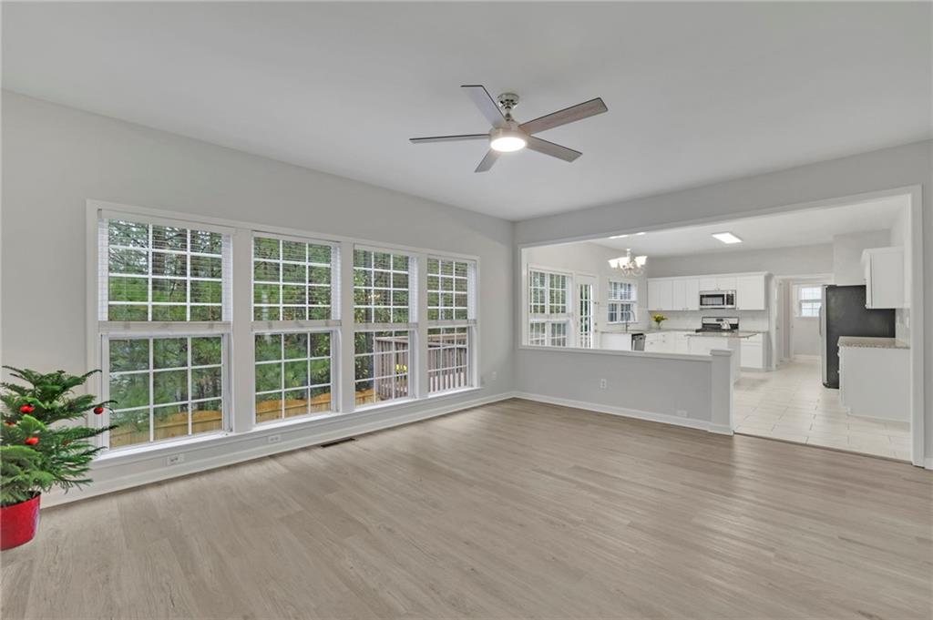11420 Crossington Road Alpharetta, GA 30005 - Photo 11 of 39 a view of an empty room with a window and wooden floor