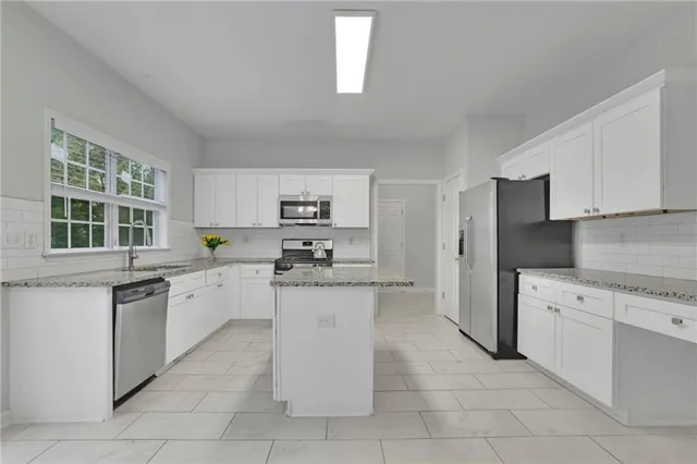 a view of an empty room with a fireplace and chandelier