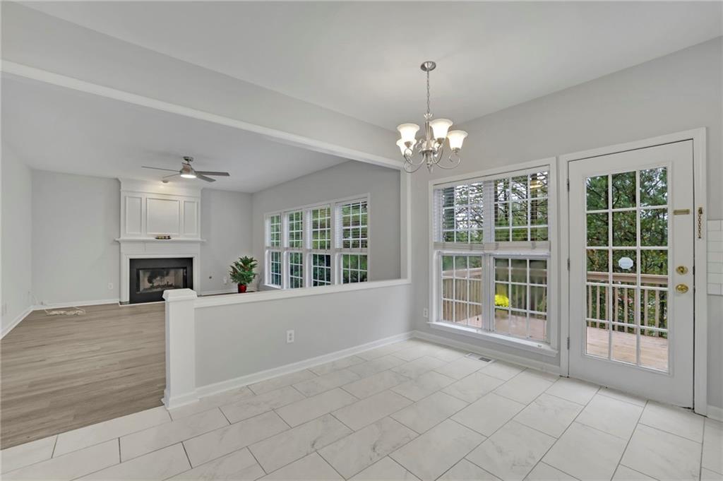 11420 Crossington Road Alpharetta, GA 30005 - Photo 16 of 39 a view of an empty room with a fireplace and chandelier
