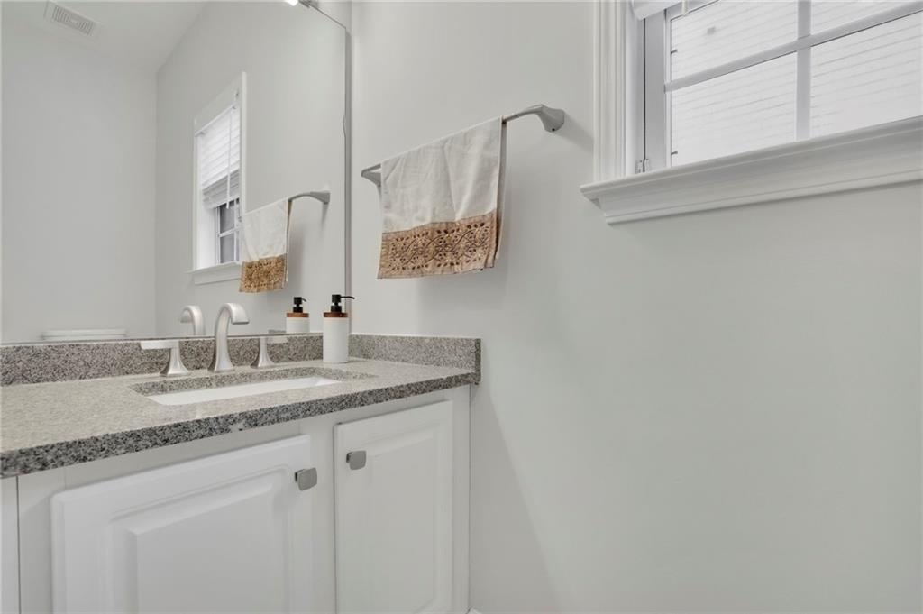 11420 Crossington Road Alpharetta, GA 30005 - Photo 19 of 39 a bathroom with a granite countertop sink and a mirror