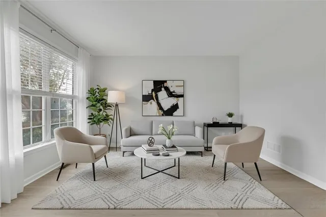 a view of a livingroom with a fireplace a ceiling fan and windows