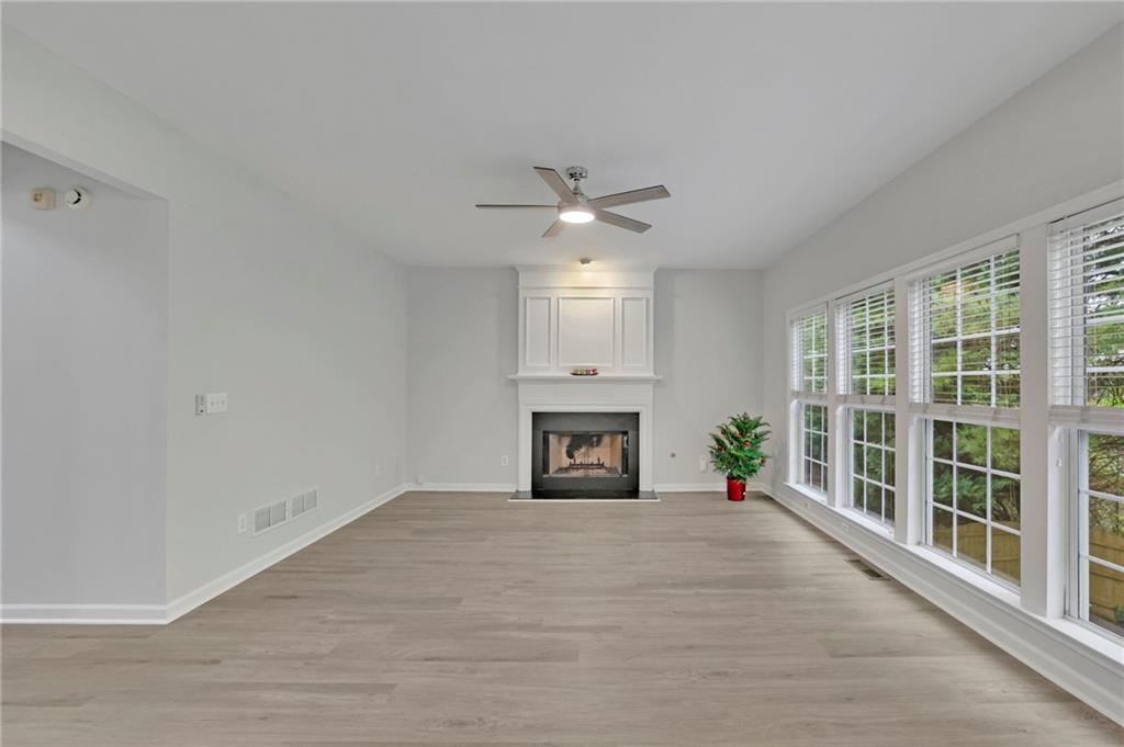 11420 Crossington Road Alpharetta, GA 30005 - Photo 10 of 39 a view of a livingroom with a fireplace a ceiling fan and windows
