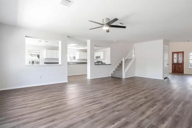 a view of empty room with wooden floor and window