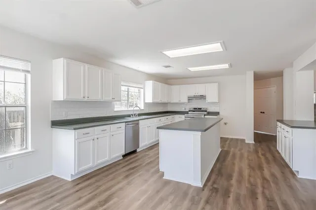 a kitchen with granite countertop a sink a counter top space and appliances