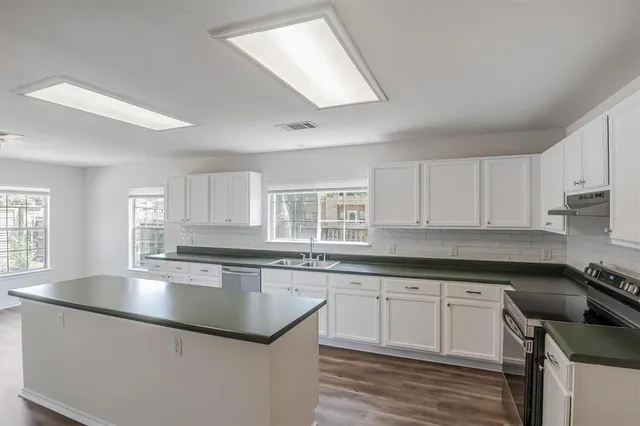 a kitchen with granite countertop white cabinets and white appliances