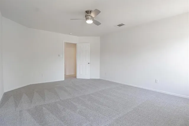 a view of an empty room with a ceiling fan