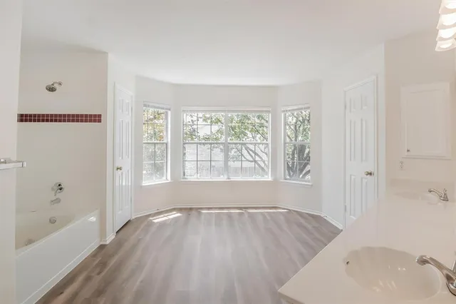a view of a room with wooden floor and a window