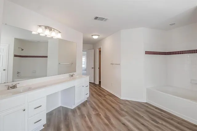 a bathroom with a double vanity sink and a mirror