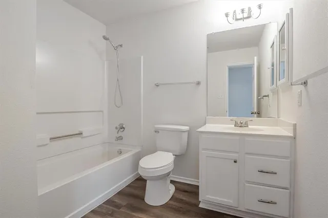 a bathroom with a granite countertop toilet a sink and a bathtub