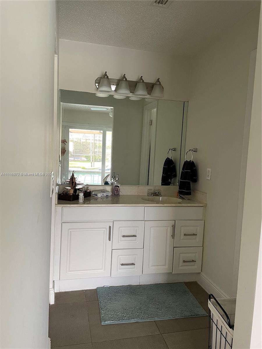 19625 Back 9 Drive Boca Raton, FL 33498 - Photo 10 of 13 a bathroom with a sink vanity and mirror
