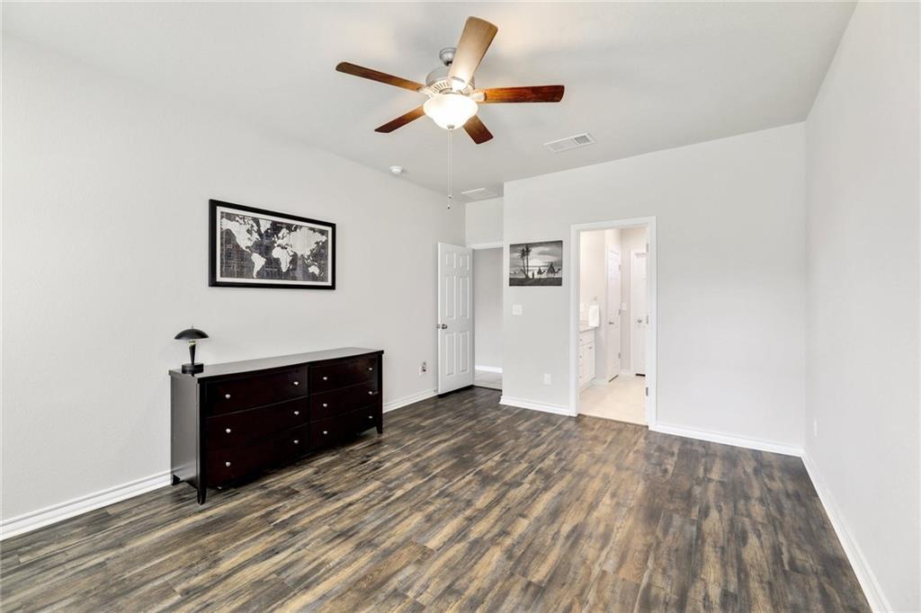 204 Tulum Terrace Leander, TX 78641 - Photo 5 of 22 Unfurnished bedroom with dark wood-style flooring, a ceiling fan, and connected bathroom