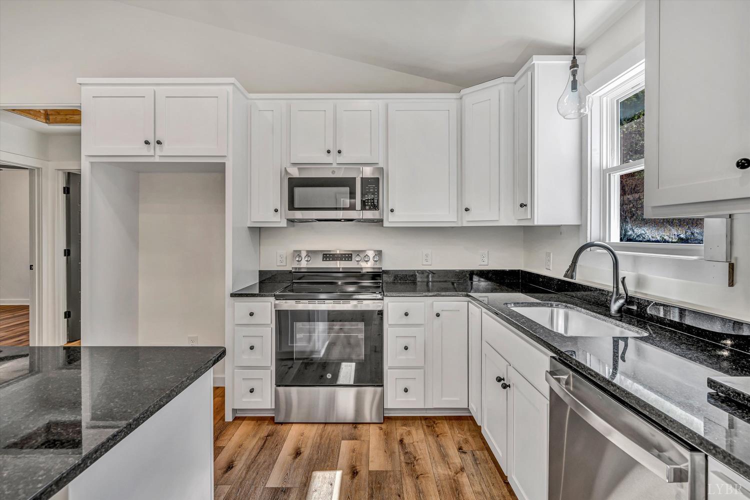1484 White House Road Moneta, VA 24121 - Photo 9 of 27 a kitchen with stainless steel appliances granite countertop a stove a sink and a white cabinets