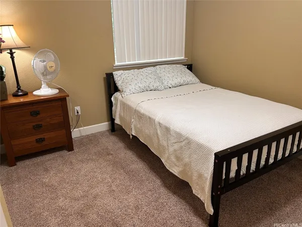 a bedroom with a bed and a potted plant