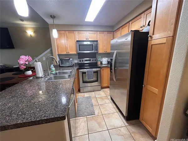 a kitchen with stainless steel appliances granite countertop a refrigerator and a sink