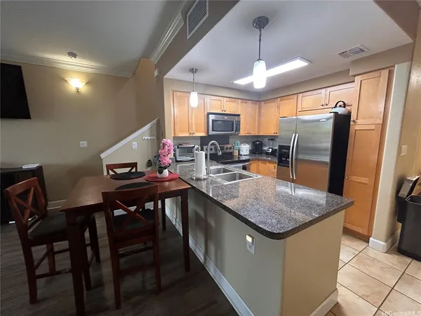 a kitchen with stainless steel appliances granite countertop sink stove top oven table and chairs