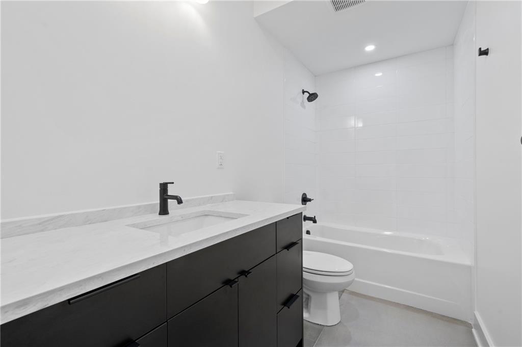 226 38th Street Pittsburgh, PA 15201 - Photo 23 of 42 a bathroom with a granite countertop sink toilet a bathtub and a shower
