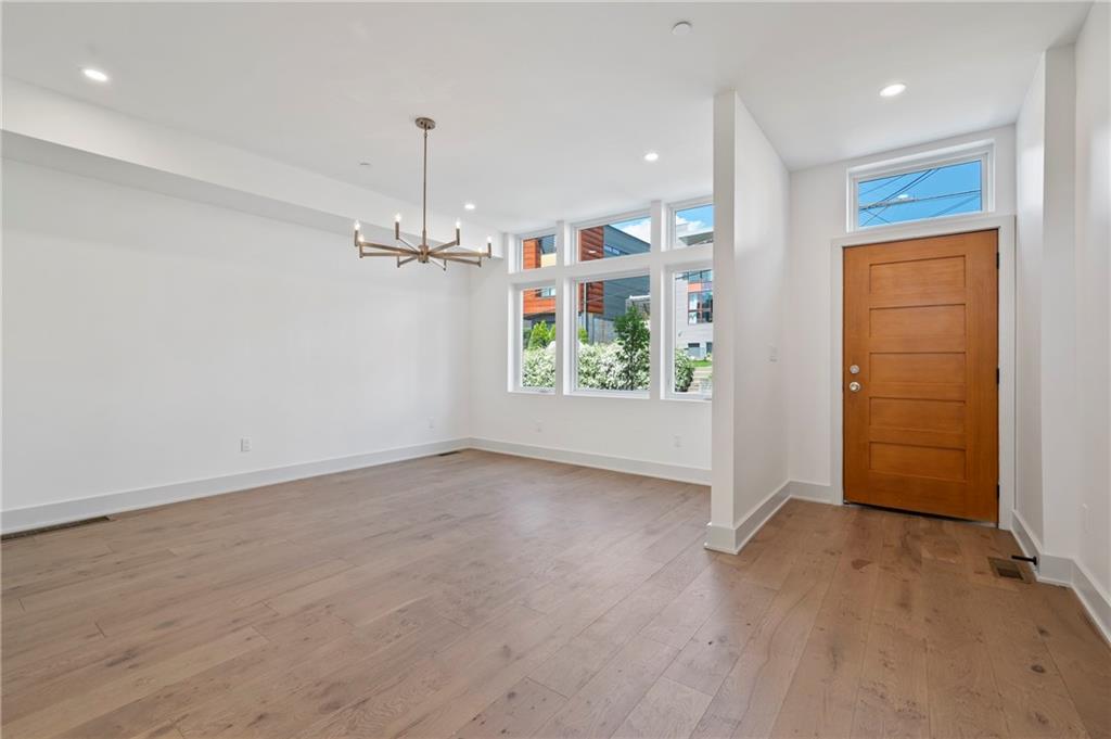 226 38th Street Pittsburgh, PA 15201 - Photo 4 of 42 an empty room with wooden floor a ceiling fan and windows