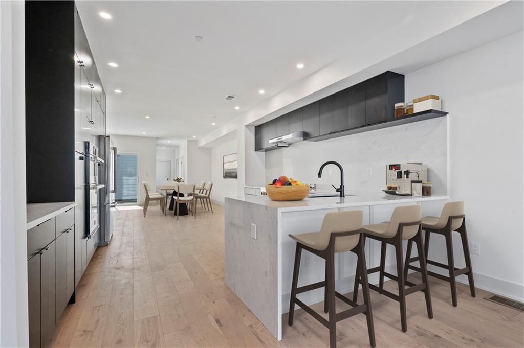 226 38th Street Pittsburgh, PA 15201 - Photo 8 of 42 a dinning room with stainless steel appliances a table and chairs with wooden floor