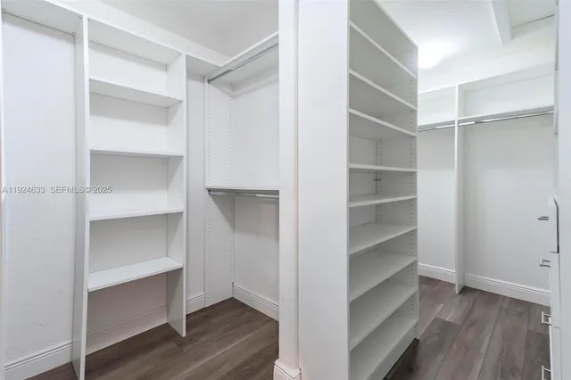 a view of a big room with closet and a chandelier fan