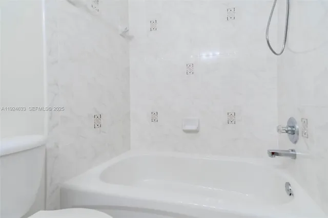 a living room with furniture a table and kitchen view