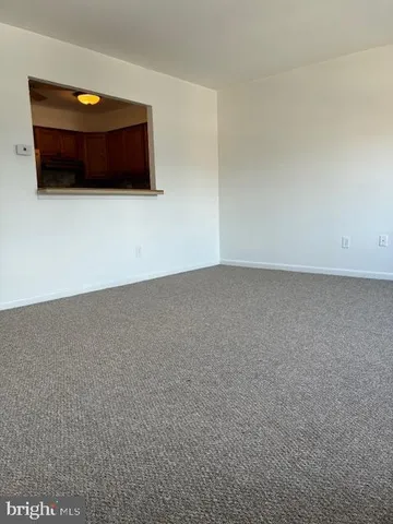 a view of an empty room and kitchen
