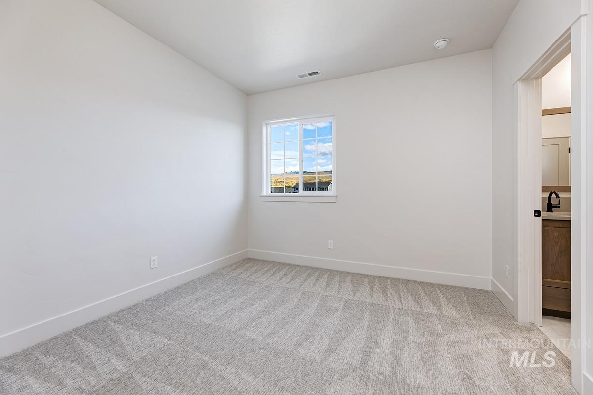 13424 North Spring Creek Way Boise, ID 83714 - Photo 27 of 43 Empty room with light carpet and baseboards