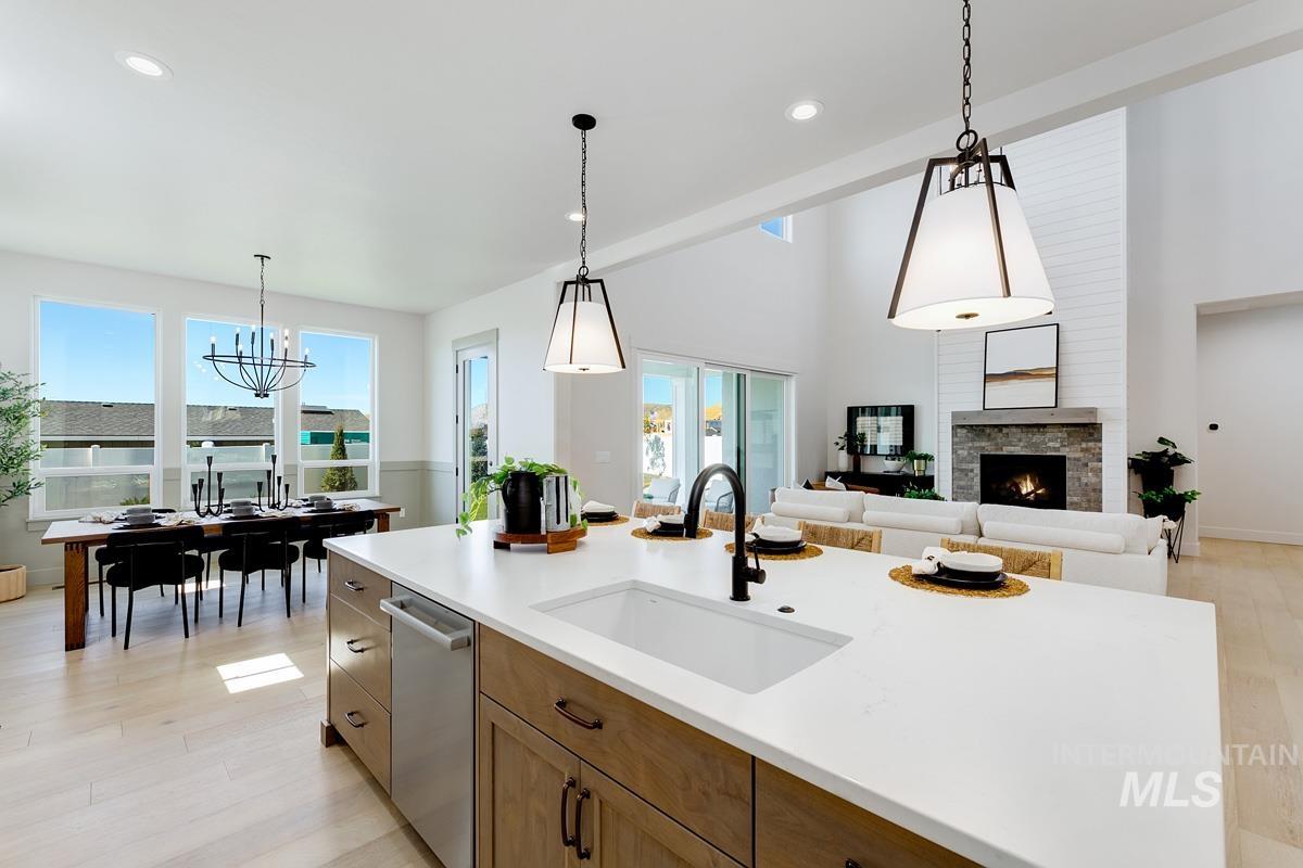 13424 North Spring Creek Way Boise, ID 83714 - Photo 43 of 43 Kitchen with light wood finished floors, wood finish cabinets, a stone fireplace, stainless steel dishwasher, and open floor plan