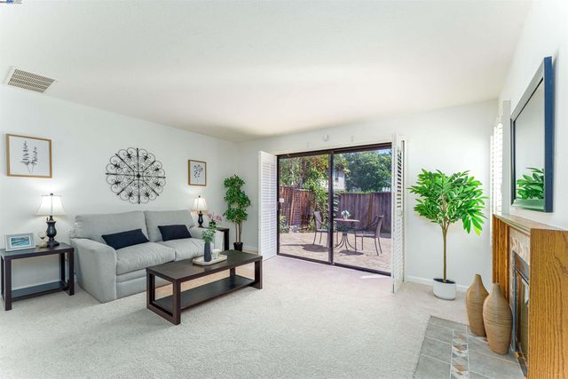 a living room with furniture a potted plant and a window