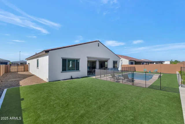 a view of a backyard with lawn chairs