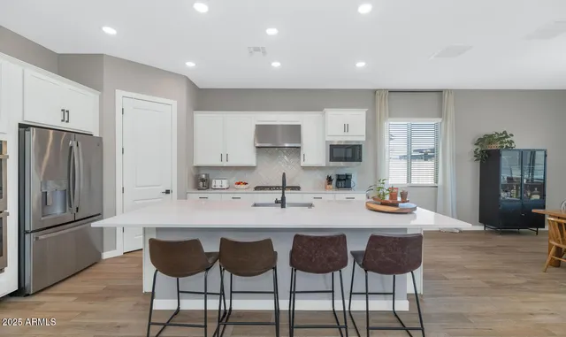 a kitchen with granite countertop a refrigerator and a dining table