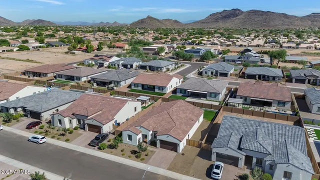 an aerial view of a house with a mountain