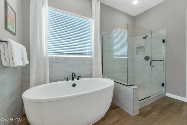 a white bath tub sitting next to a shower