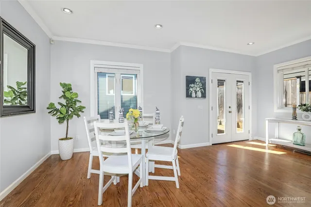 a dining room with furniture potted plants and wooden floor
