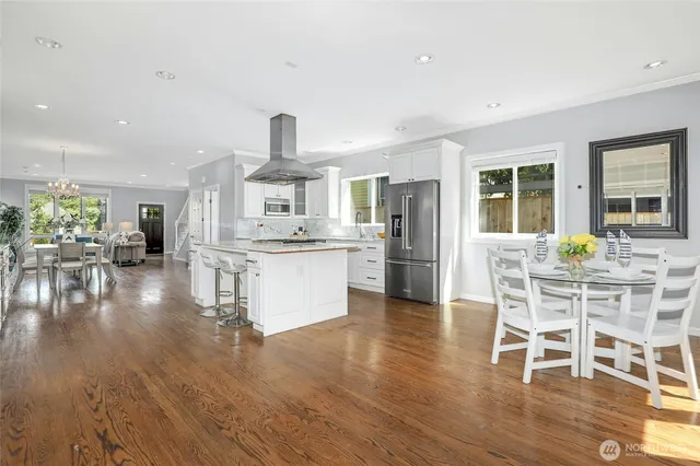 a view of a dining room with furniture a rug and wooden floor
