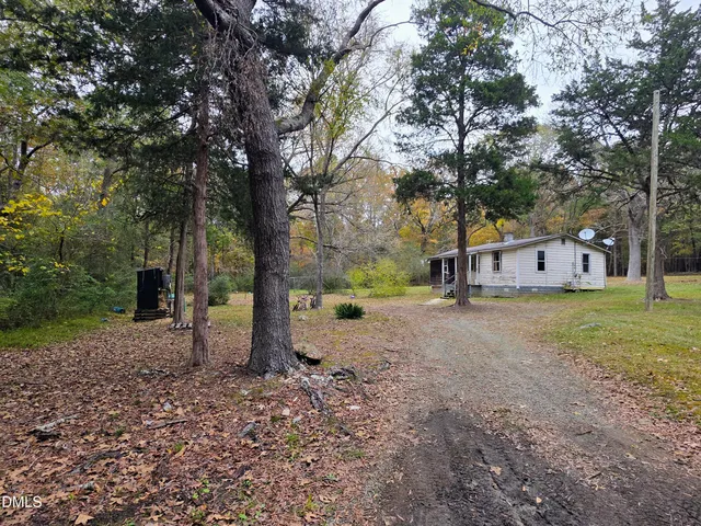 a view of a house with a yard and tree s