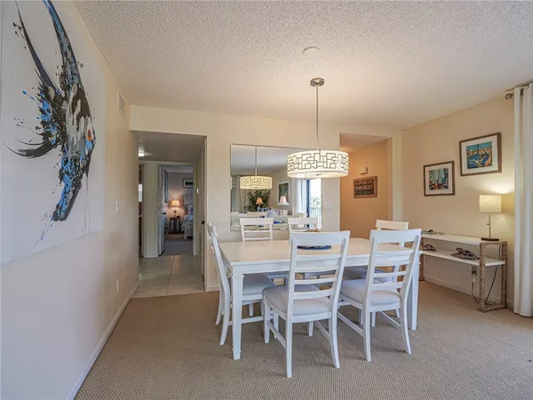 a dining room with furniture a chandelier and window