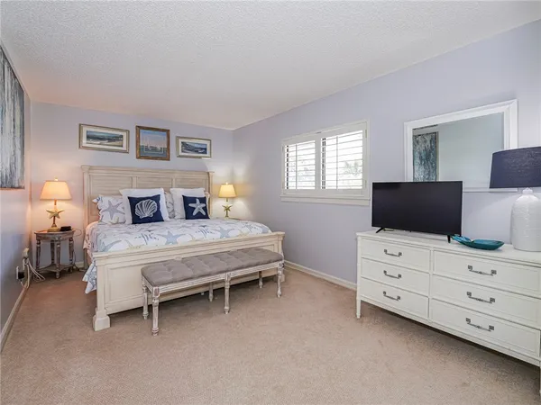 a bedroom with a bed and tv on dresser