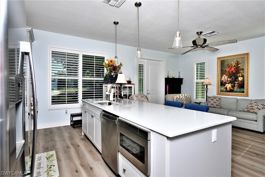 23170 North River Road Alva, FL 33920 - Photo 11 of 50 a kitchen with kitchen island a stove a sink a dining table and chairs