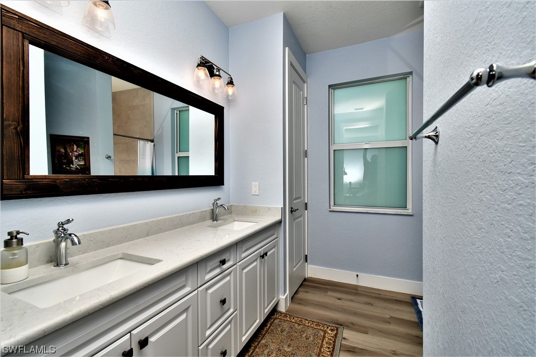 23170 North River Road Alva, FL 33920 - Photo 18 of 50 a bathroom with a double vanity sink and a mirror