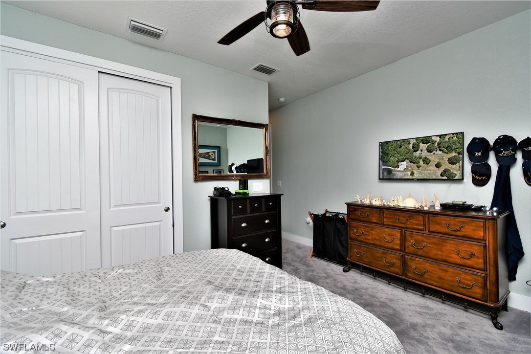23170 North River Road Alva, FL 33920 - Photo 29 of 50 a bedroom with a bed and a dresser