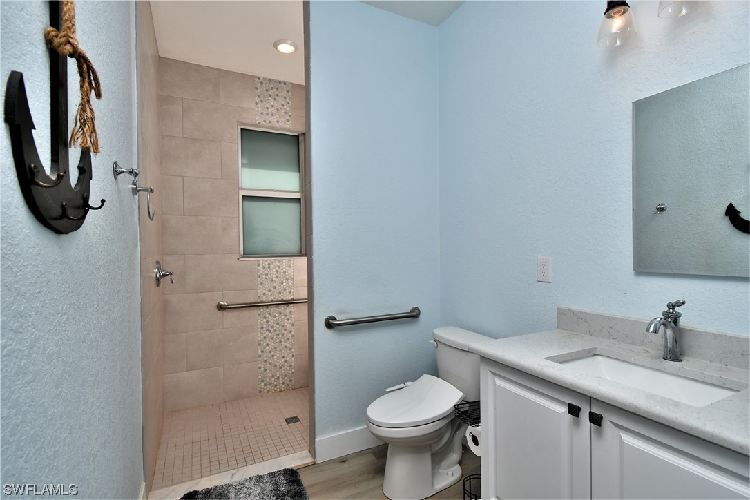 23170 North River Road Alva, FL 33920 - Photo 30 of 50 a bathroom with a granite countertop sink toilet and shower