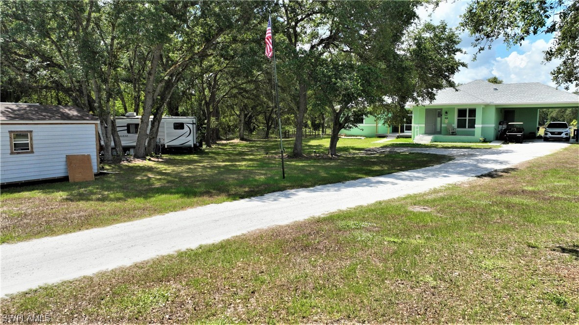 23170 North River Road Alva, FL 33920 - Photo 3 of 50 a view of a house with a yard and tree s