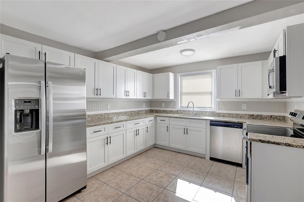5605 Oceanic Road Holiday, FL 34690 - Photo 12 of 36 a kitchen with granite countertop stainless steel appliances a sink and a refrigerator