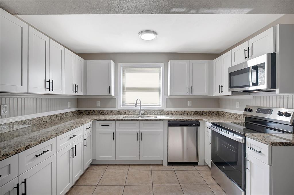 5605 Oceanic Road Holiday, FL 34690 - Photo 13 of 36 a kitchen with a sink stove top oven and cabinets