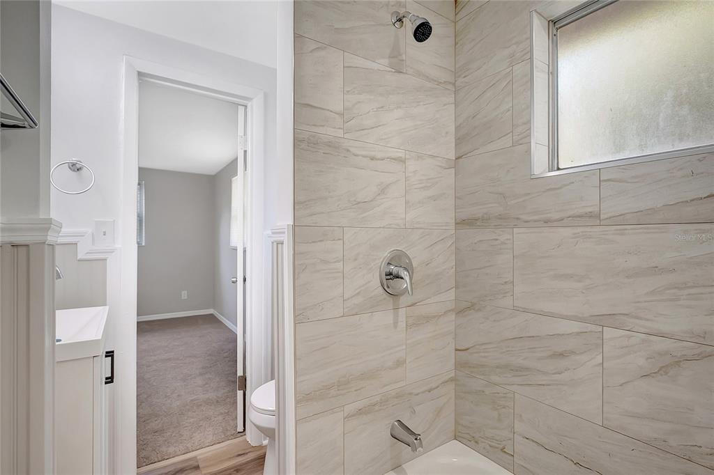 5605 Oceanic Road Holiday, FL 34690 - Photo 25 of 36 a bathroom with a glass shower door