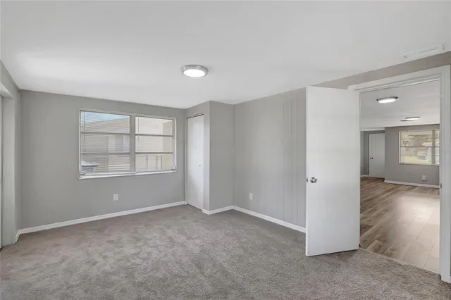 an empty room with windows and closet